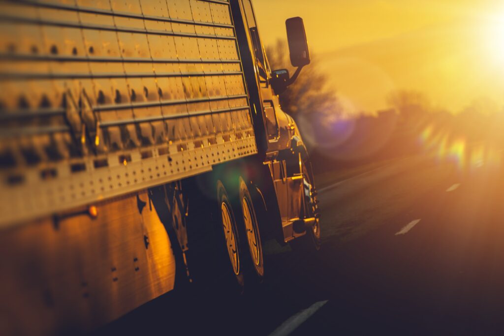 sunlight on side of semi truck racing down highway
